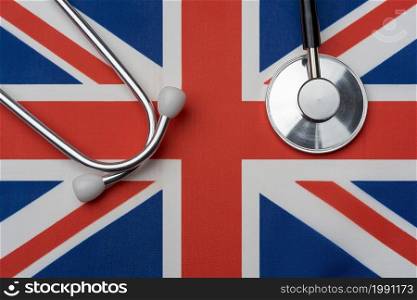 UK flag and stethoscope. The concept of medicine. Stethoscope on the flag in the background.. UK flag and stethoscope. The concept of medicine.