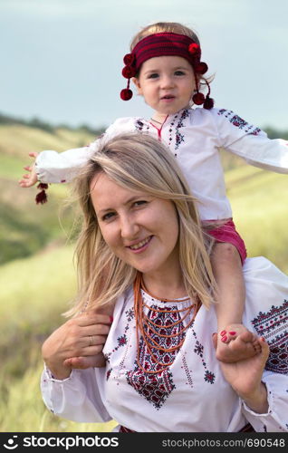 Ukrainian family at the outdoor. mom and daughter in traditional national clothes vyshivanka
