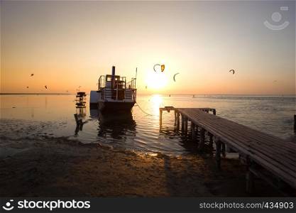 Ukrainian landscape. view of the the sea Azov with the ship and pier in the foreground in sunset time, Ukraine
