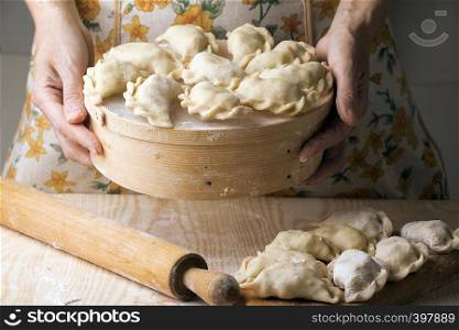 Ukrainian traditional bakery products - Making pierogies by female hands. Rustic style. Retro Photo