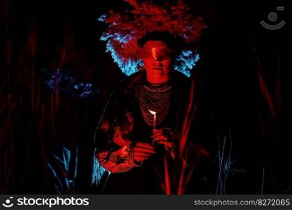 Ukrainian woman as motanka with candle in reeds at night. Red ribbon around eyes as on ritual rag doll. Traditional costume. Symbolism, ancient magic, force of nature, cosplay . Ukrainian woman as motanka with candle. Ribbon around eyes as on ritual rag doll