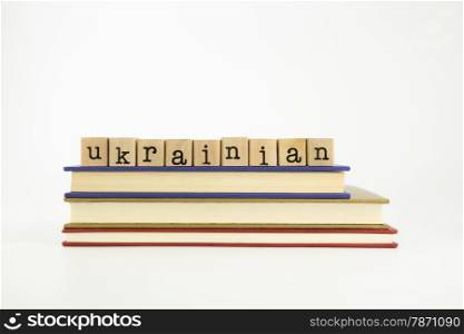 ukrainian word on wood stamps stack on books, language and conversation concept