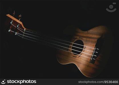 Ukulele musical instrument on black background