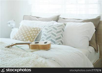 Ukulele on bed in pastel color bedroom style interior