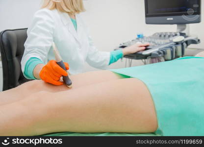 Ultrasound examination of leg veins, apparatus ultrasound doctor girl legs vessels vascular surgeon.. Ultrasound examination of leg veins. Ultrasound vessels at thigh, leg.