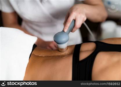Ultrasound in Physical Therapy. Therapist Using Ultrasound Applicator on a Patient’s Lower Back