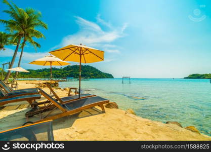 Umbrella and chair on the Beautiful tropical beach and sea with coconut palm tree in paradise island for travel and vacation