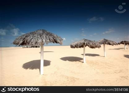 umbrella in desert under blue sky