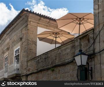 Umbrellas on rooftop restaurant in the old town of Guimaraes. Rooftop restaurant on stone houses in Guimaraes in Portugal