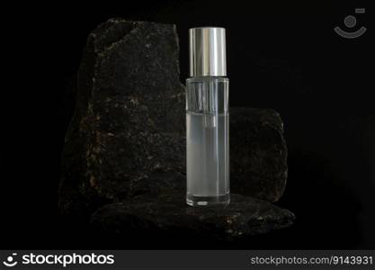 Unbranded natural cosmetic serum packaging standing on stone podium. Serum presentation on the black background. Mockup. Trending concept in natural materials. Natural cosmetic, skincare. Unbranded natural cosmetic serum packaging standing on stone podium. Serum presentation on the black background. Mockup. Trending concept in natural materials. Natural cosmetic, skincare.