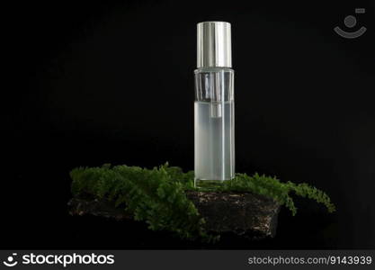 Unbranded natural cosmetic serum packaging standing on stone podium. Serum presentation on the black background. Mockup. Trending concept in natural materials. Natural cosmetic, skincare. Unbranded natural cosmetic serum packaging standing on stone podium. Serum presentation on the black background. Mockup. Trending concept in natural materials. Natural cosmetic, skincare.