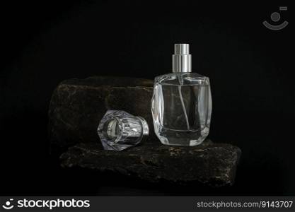Unbranded perfume bottle standing on stone podium. Perfume presentation on the black background. Mockup. Trending concept in natural materials. Women’s and men’s essence. Natural cosmetic. Unbranded perfume bottle standing on stone podium. Perfume presentation on the black background. Mockup. Trending concept in natural materials. Women’s and men’s essence. Natural cosmetic.