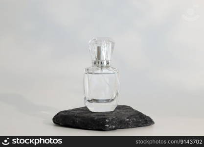 Unbranded perfume bottle standing on stone podium. Perfume presentation on the white background. Mockup. Trending concept in natural materials. Women’s and men’s essence. Natural cosmetic. Unbranded perfume bottle standing on stone podium. Perfume presentation on the white background. Mockup. Trending concept in natural materials. Women’s and men’s essence. Natural cosmetic.