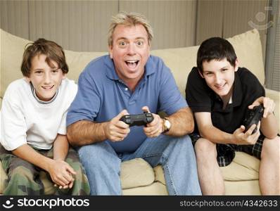 Uncle or father playing video games with two boys.