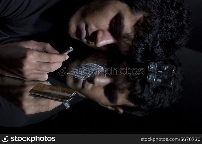 Unconscious man with drugs and rolled up banknote