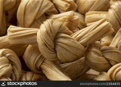 Uncooked bean curd knot full frame close up as background