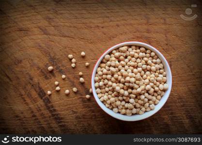 Uncooked chickpeas in bowl on wooden background. top view .. Uncooked chickpeas in bowl on wooden background. top view