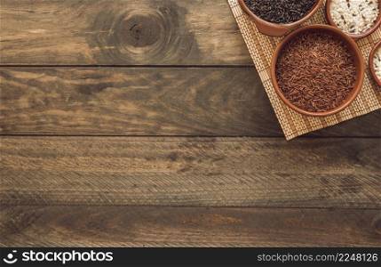 uncooked different rice bowls placemat wooden background