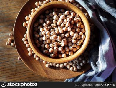 Uncooked dried chickpeas in wooden bowl on wooden rustic table. Heap of legume chickpea background .. Uncooked dried chickpeas in wooden bowl on wooden rustic table. Heap of legume chickpea background