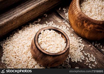 Uncooked dry rice in wooden bowl.Nature food. Uncooked dry rice