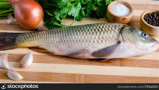 Uncooked fish on cutting board in meal preparation concept. The uncooked fish on cutting board in meal preparation concept