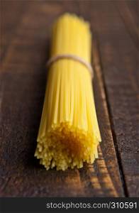 Uncooked pasta spaghetti macaroni on wooden background. RAW