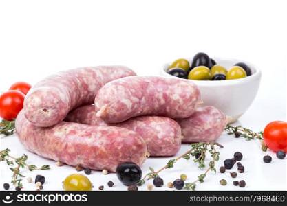 uncooked raw sausages with serving spices on white background