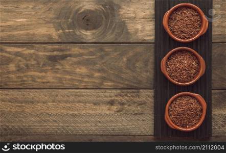 uncooked red jasmine rice bowls placemat wooden background