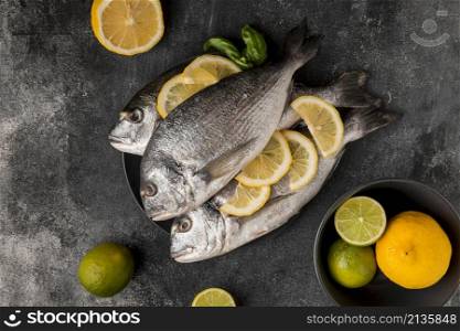 uncooked seafood fish with slices lemon top view