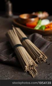 Uncooked soba and udon noodles. Traditional Japanese noodles on wooden table.