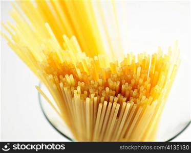 uncooked spaghetti on white background, close up
