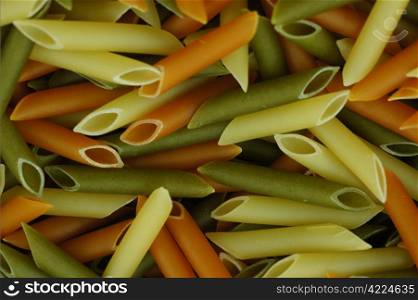 uncooked spaghetti tubes colored background of macro. spaghetti