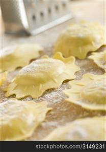 Uncooked Spinach and Ricotta Ravioli on a floured surface