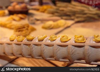 Uncooked Tortellini Italian Pasta Shown on Wooden Cylinder