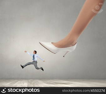 Under boss pressure. Businesswoman foot stepping on tiny businessman presenting power concept