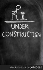 Under construction concept drawn in chalk on a blackboard