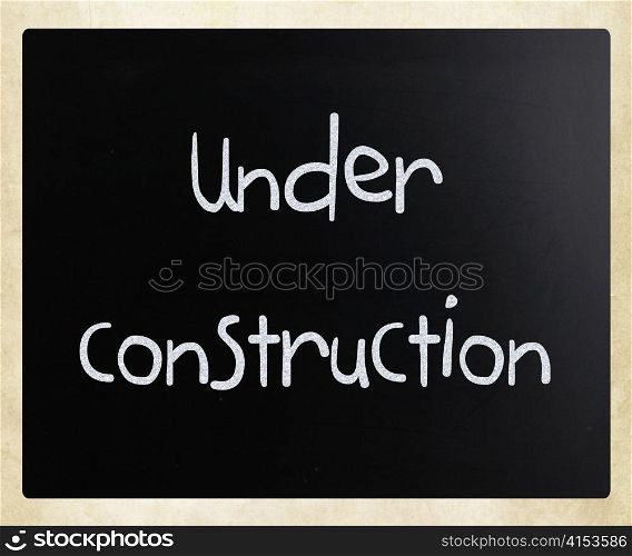""Under construction" handwritten with white chalk on a blackboard"