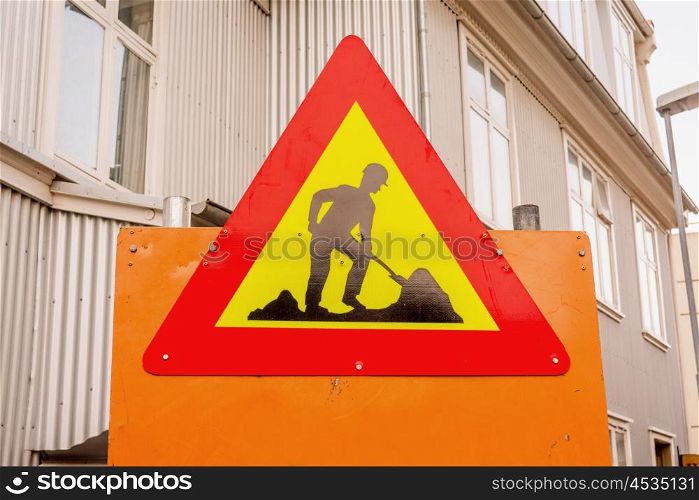 Under construction sign in a street with buildings