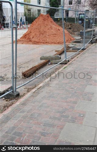 under construction site with metallic fence by the sidewalk at a urban area