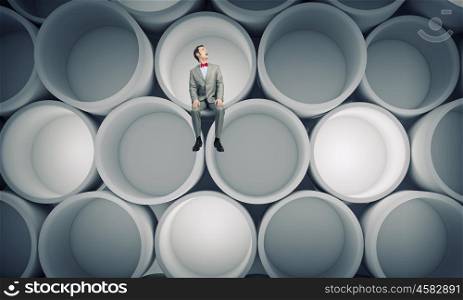 Under pressure. Young scared businessman sitting and looking up