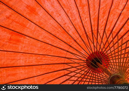 Underside of red fabric umbrella with bamboo frame