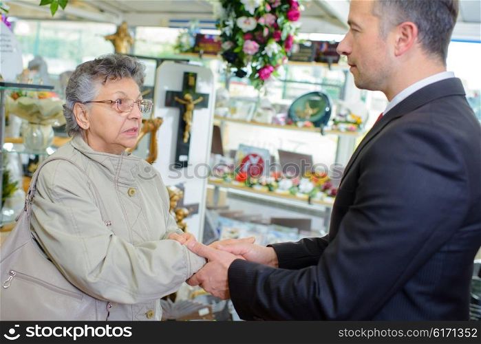 Undertaker shaking hand of elderly lady