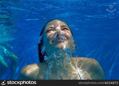 Underwater head and shoulder view of girl underwater swimming in swimming pool