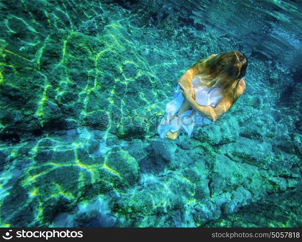 Underwater meditating, beautiful woman sitting on the bottom of the sea, zen balance, active lifestyle, summer time relaxation concept