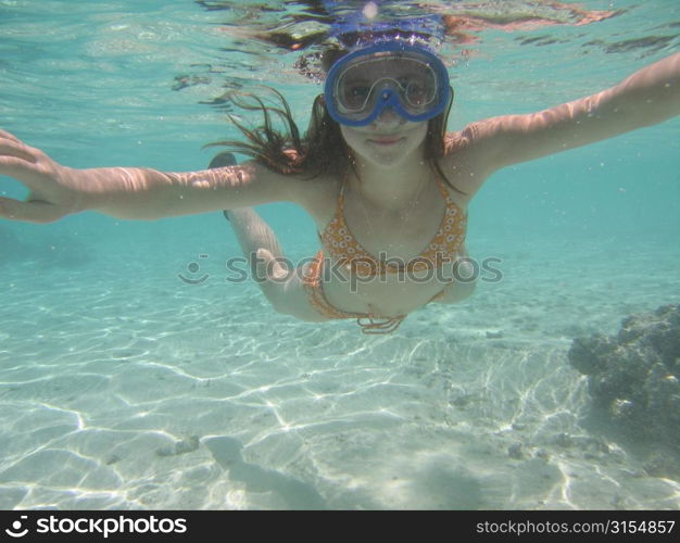 Underwater view of a young woman scuba diving, Moorea, Tahiti, French Polynesia, South Pacific