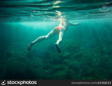 Underwater view of mid adult woman swimming, Menorca, Balearic islands, Spain