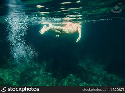 Underwater view of woman swimming, Menorca, Balearic islands, Spain