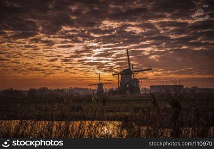 UNESCO World Heritage windmills in Kinderdijk in Holland europe, windmills at the water with reflection and twilight at sunset