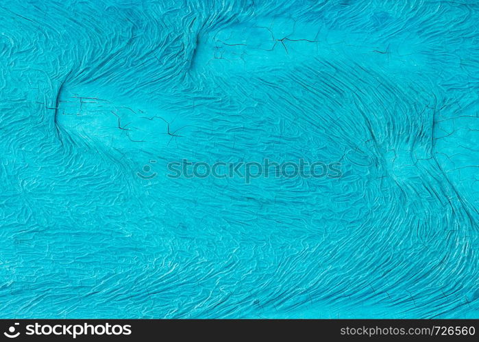 Unevenly painted surface of blue color with cracks and with wavy irregular pattern. background, texture