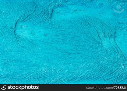 Unevenly painted surface of blue color with cracks and with wavy irregular pattern. background, texture